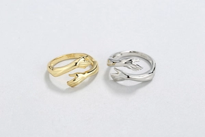 Macro shot of S925 hallmark on gold and silver hugging hands open rings