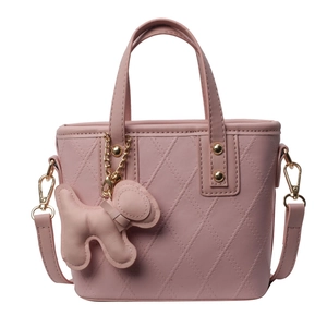 Sac seau matelassé rose avec breloque chiot et bandoulière réglable sur fond blanc