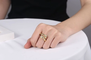 Detailed view of gold embrace hands ring showing polished metal texture and hugging design