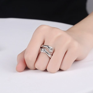 Minimalist silver hug ring with adjustable open design featuring embracing hands