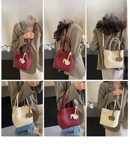 Chic bucket bag set in burgundy and beige leather featuring elephant charms and straps