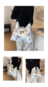 Detail view of white butterfly tote bag with silver metal bow and chain strap accents