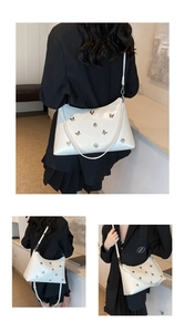 Détail du sac cabas blanc brillant avec papillon doré et bandoulière réglable mince