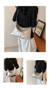 Détail des breloques papillon et cœur en métal argenté sur un sac porté épaule Y2K