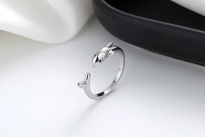 Macro detail of silver shark open ring featuring a vivid blue gemstone eye and polished finish