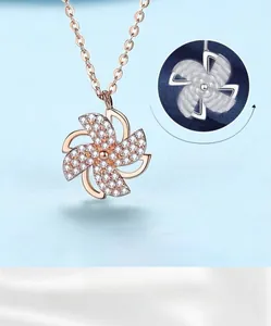 Close-up of a rotating rose gold windmill pendant with sparkling zirconia stones