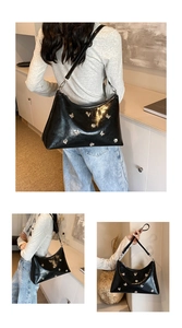 Détail du sac croissant en cuir noir brillant avec breloques papillon argentées