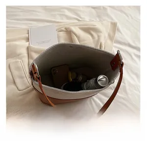 Spacious interior of canvas tote bag holding a phone, thermos, and folding umbrella