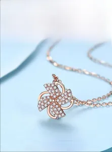Macro shot of rose gold windmill pendant necklace with sparkling white crystals