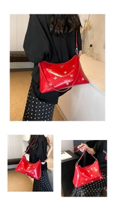 Détail du cabas en cuir verni rouge avec papillon en métal et bandoulière fine
