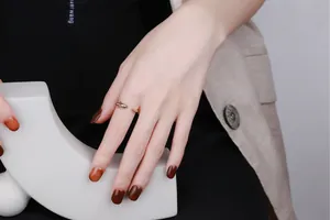 Detailed close-up of golden shark open ring with 3D animal design worn by a female model