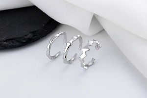 Close-up of S925 sterling silver stamp on irregular organic wave rings set