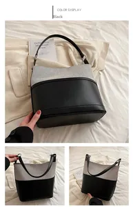 Detail view of a black leather and canvas bucket bag showing textured contrast and strap