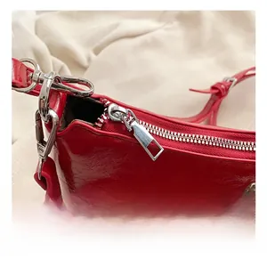 Macro des rivets argentés et de la fermeture éclair sur le sac en cuir ciré rouge