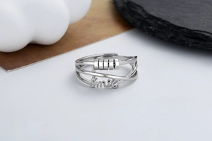 Detail of adjustable silver ring with four rotatable beads and Smile engraving