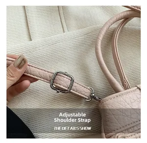 Detail of pink lychee leather handbag with adjustable strap and silver metal hardware