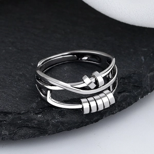 Macro detail of adjustable silver spinner ring with five sliding beads on black stone