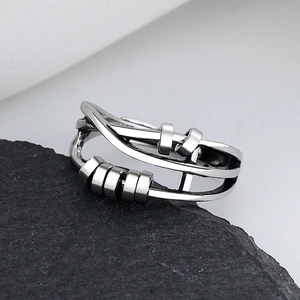 Detailed view of silver rotatable bead ring on black mineral stone background