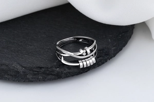 Macro shot of S925 silver fidget ring with sliding beads on a textured dark stone base