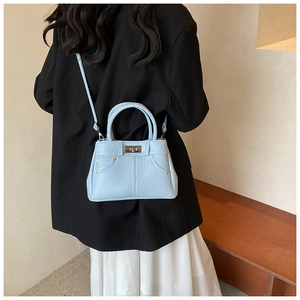 Detail of light blue Kelly bag with denim elements and silver turn-lock closure on model