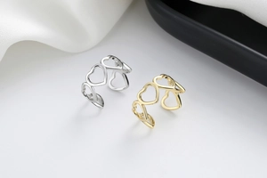 Detail of adjustable hollow heart rings in polished gold and silver plating finishes