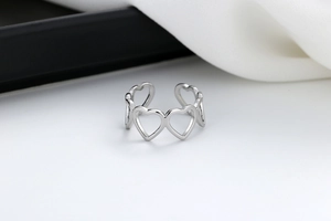 Close-up of polished silver hollow heart pattern on adjustable open ring band