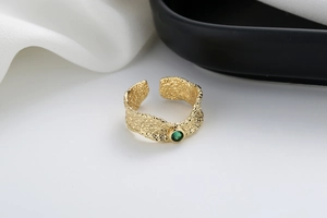 Detailed macro view of irregular gold lava texture ring with a green zircon stone
