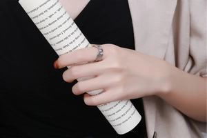 Detail of silver textured wide ring with a small red zircon stone on a model hand