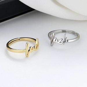 Macro shot of minimalist adjustable gold and silver luck letter rings with polished finish