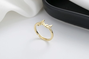 Macro detail of adjustable gold ring with luck lettering design on white satin
