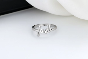 Detail shot of the polished silver Luck letter ring with an adjustable open band design
