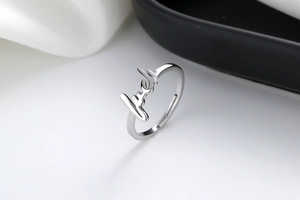 Detailed close-up of adjustable silver luck letter ring with high-polished metal finish