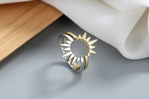 Dettaglio macro dell'anello bicolore con punte geometriche a raggiera solare