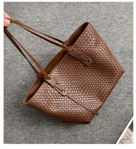 Detailed view of the brown woven leather texture and interior of the large tote bag