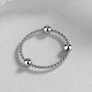 Silver twisted rope ring with three polished metal beads in a minimalist fashion style