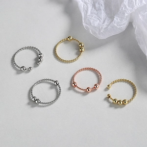 Minimalist twisted fidget ring set in gold, silver and rose gold with sliding beads