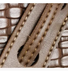 Detail of premium brown woven texture and precise double stitching on bag strap