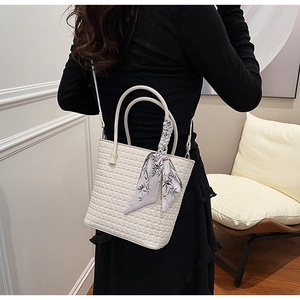 Detail of white woven leather tote bag with elegant silk scarf and shoulder strap