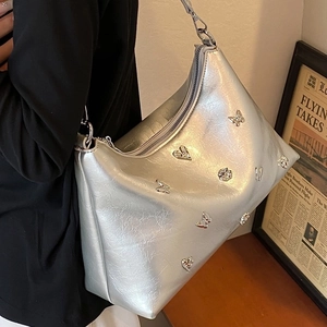 Sac fourre-tout argenté métallisé avec papillon et breloques cœur pour un look chic