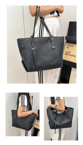 Detailed view of large black woven tote bag with leather straps and geometric texture