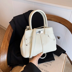 Chic cream white handbag with rivet denim pocket design on office blazer background