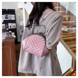 Pink quilted shell bag featuring V-shaped stitching and a metal ring handle accessory