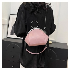 Quilted pink crossbody bag detail with silver ring handle and chain strap on shoulder