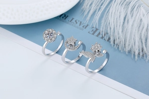 Detailed view of three silver-tone adjustable rings with zircon butterfly and star shapes