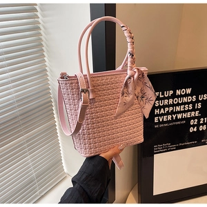 Detail of pink woven bucket bag with floral silk scarf handle and thin shoulder strap