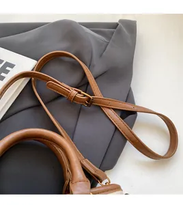 Vue détaillée de la bandoulière en cuir réglable et du patchwork de tissus sur le sac seau