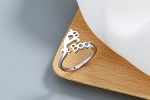 Detailed view of silver open ring with animal paw prints and 'Boo' engraving