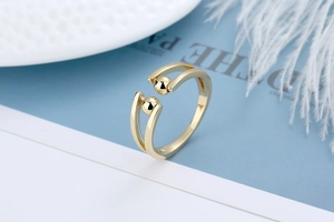 Detail of adjustable gold anxiety ring with rotating beads on minimalist double band