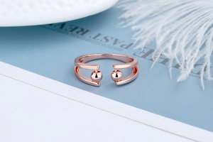 Detail of rose gold adjustable ring with dual beads on a minimalist parallel band