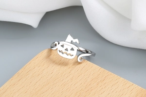 Macro view of silver Halloween ring featuring a hollow pumpkin face and witch hat design